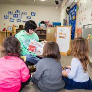 A teacher reads a a book to the class.